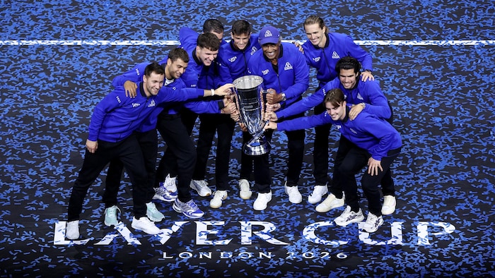Des joueurs de tennis célèbrent avec un trophée. 