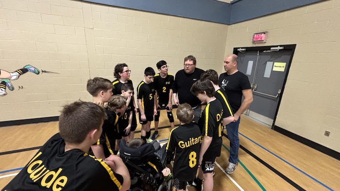 Joueurs regroupés autour de l'entraîneur.