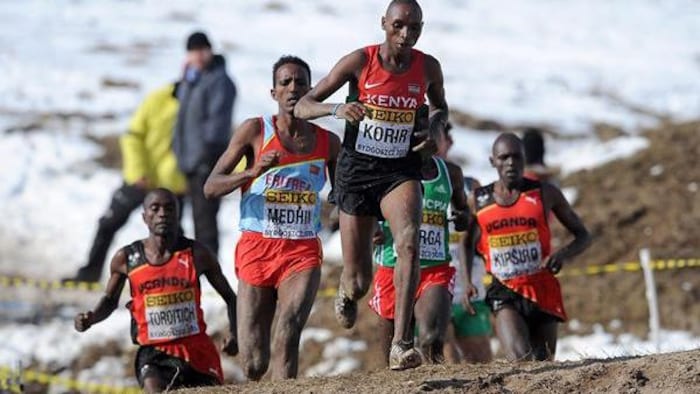 Des coureurs en pleine people   sur un sentier de boue et de neige.