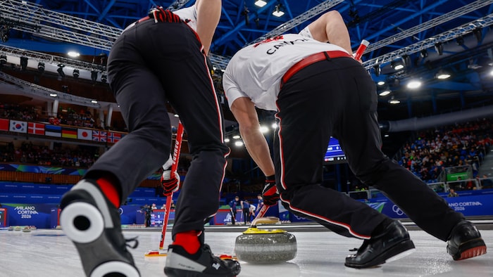 Deux curleurs balaient avec intensité pendant un match.