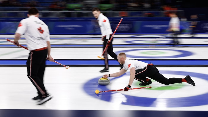 Un curleur effectue un lancer pendant un match.