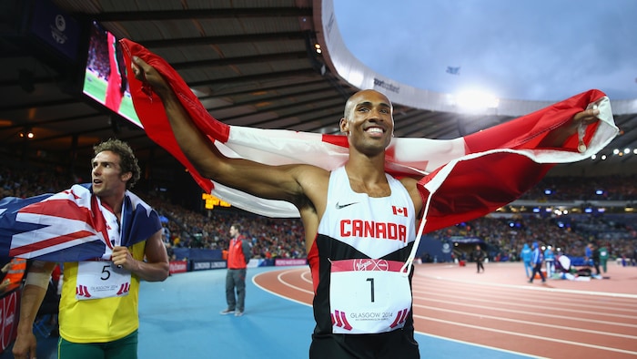 Un homme célèbre avec un drapeau canadien.