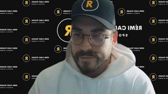 David Berthiaume-Lechasseur, avec une casquette et devant une bannière de Rémi Card Trader, est en entrevue.