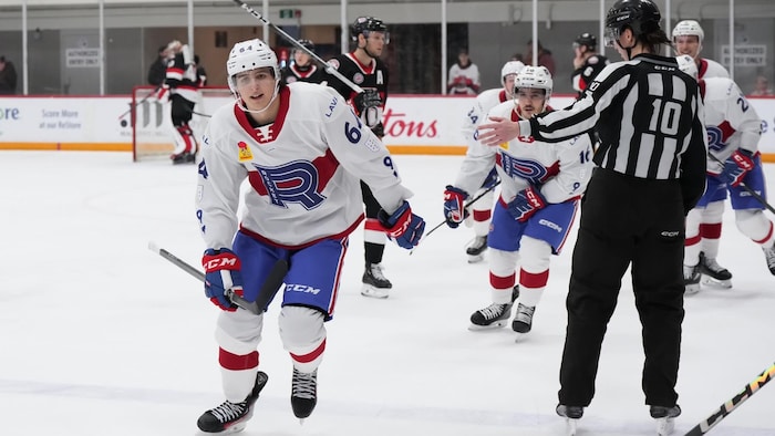 Des hockeyeurs patinent vers le banc pour célébrer un but avec leurs coéquipiers.