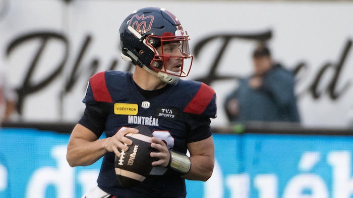 Le quart s'apprête à lancer le ballon de football.