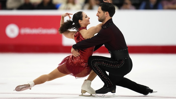 Deux patineurs effectuent une pirouette en duo.