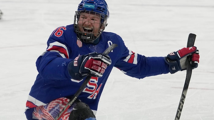 Un joueur patine sur une luge dans l'uniforme des États-Unis.