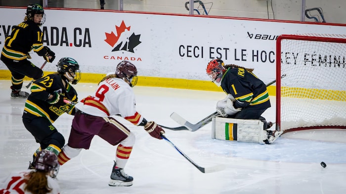 Des joueuses s'élancent vers la rondelle.