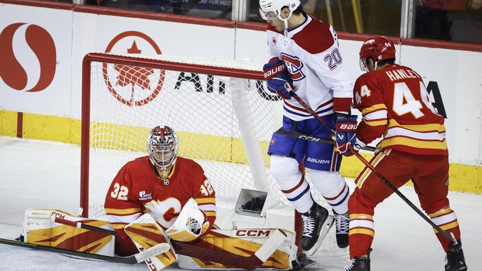 Juraj Slafkovsky des Canadiens saute dans les airs alors que Dustin Wolf réussi un arrêt.