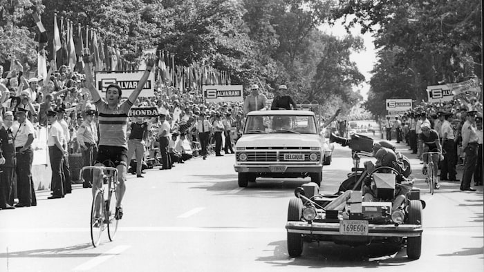Le Belge Eddy Merckx lève les bras en traversant le fil d'arrivée de l'épreuve sur route des Championnats du monde de cyclisme. À droite, derrière l'auto-caméra, le Français Raymond Poulidor se contente de la 2e place.