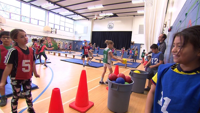De nombreux élèves font des activités dans le gymnase.