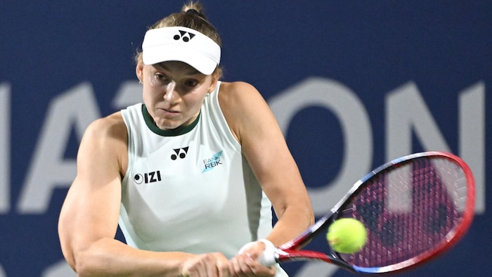 Une joueuse de tennis frappe un revers.