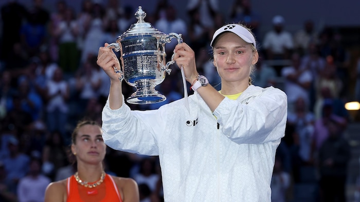 Une femme tient un trophée à deux mains.