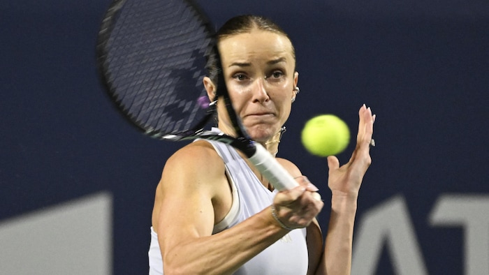Une joueuse de tennis frappe la balle du coup droit. 