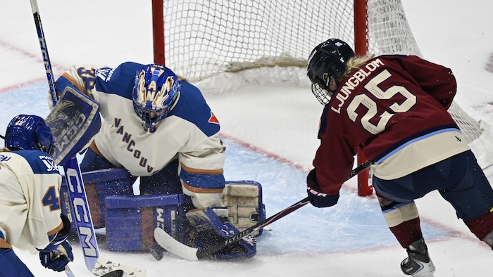 Une joueuse de hockey tente de déjouer la gardienne adverse. 