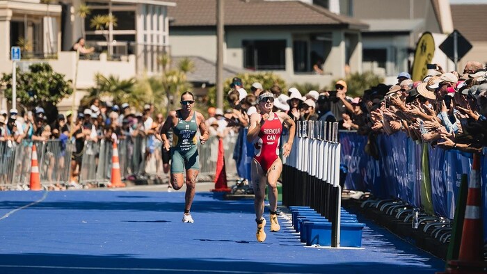 Deux athlètes effectuent un sprint près de la ligne d'arrivée.