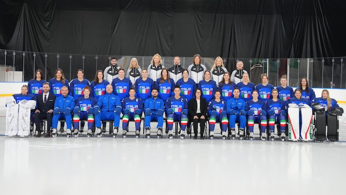 Les membres d'une équipe de hockey féminin prennent la pose sur la glace.