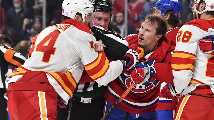 Le petit Brendan Gallagher et le grand Erik Gudbranson s'empoignent devant un arbitre qui tente de les séparer, Gallagher ne porte plus de casque.
