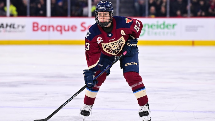 Une joueuse de hockey tient son bâton.