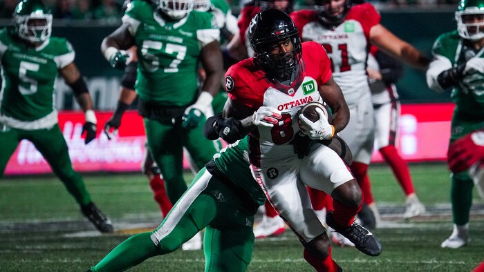 Un footballeur tente d'éviter d'être plaqué par un adversaire.