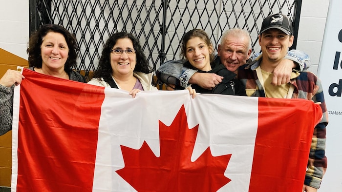 Famille devant drapeau du Canada.