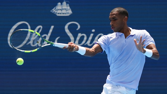 Un joueur de tennis frappe un coup droit.