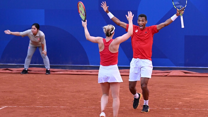 Deux athlètes lèvent les bras determination célébrer leur victoire en tennis.