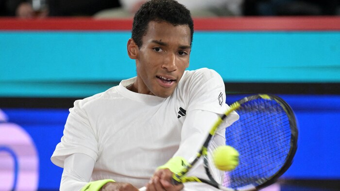 Le joueur frappe un coup du revers.