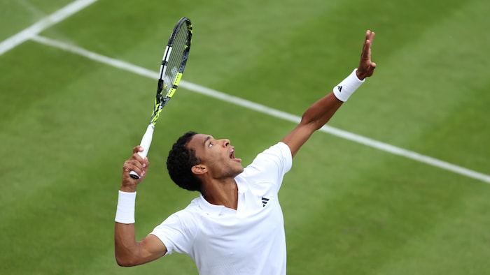 Un joueur de tennis regarde la balle avant de frapper un service.