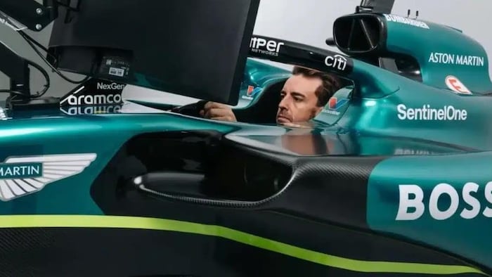 The driver, in profile, works in a car racing simulator.  
