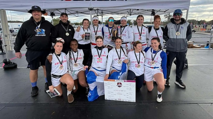 Une équipe de football prend la pose avec un trophée et des médailles après avoir remporté un tournoi.