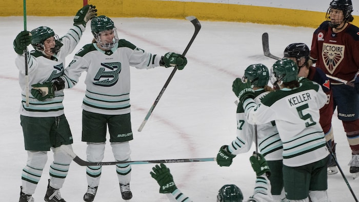 Des joueuses de hockey célèbrent un but.