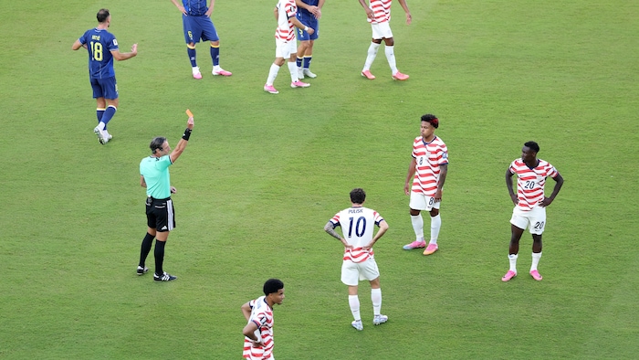 Un arbitre montre un carton rouge à un joueur.