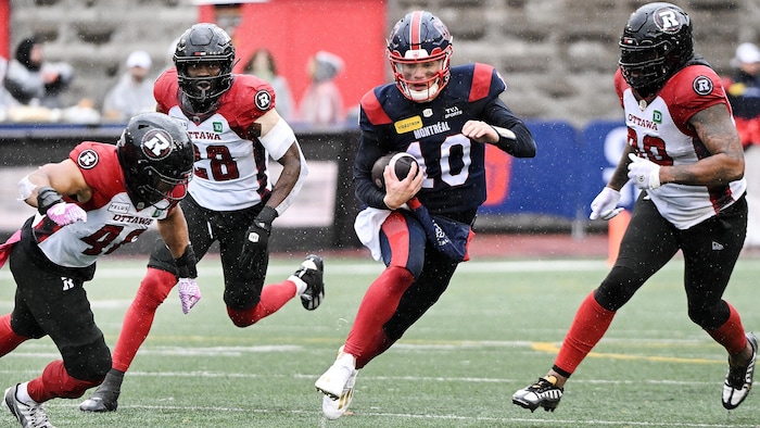 Entouré de joueurs adverses, un footballeur court avec le ballon.