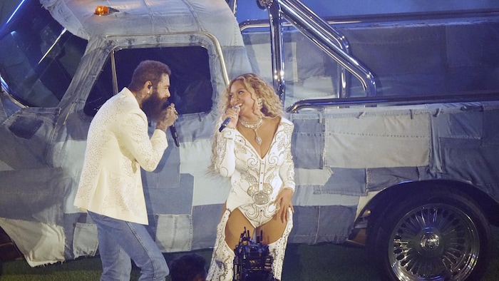 Deux artistes chantent devant un camion.