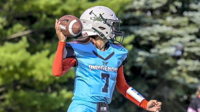 Une joueuse de football s'apprête à lancer le ballon.