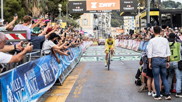 La cycliste en jaune est acclamée par de nombreux partisans.