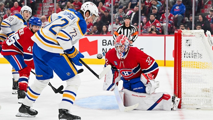 Un joueur de hockey avec la rondelle devant un gardien.