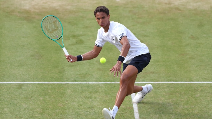 Un joueur de tennis s'apprête à frapper une balle.