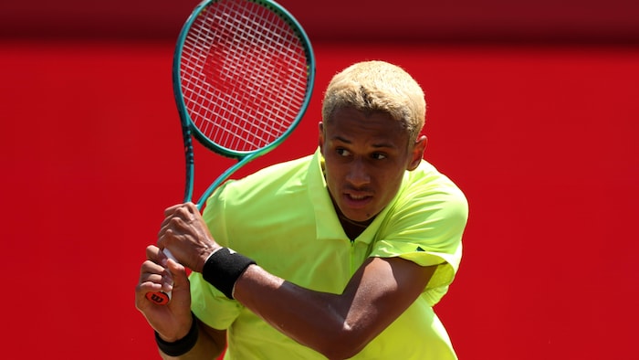 Un joueur de tennis retourne une balle.