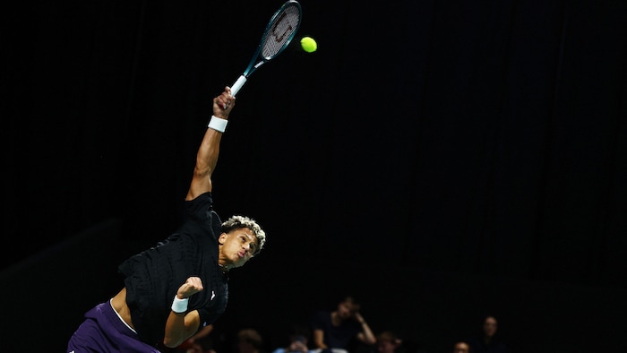 Il saute determination frapper une balle haute.