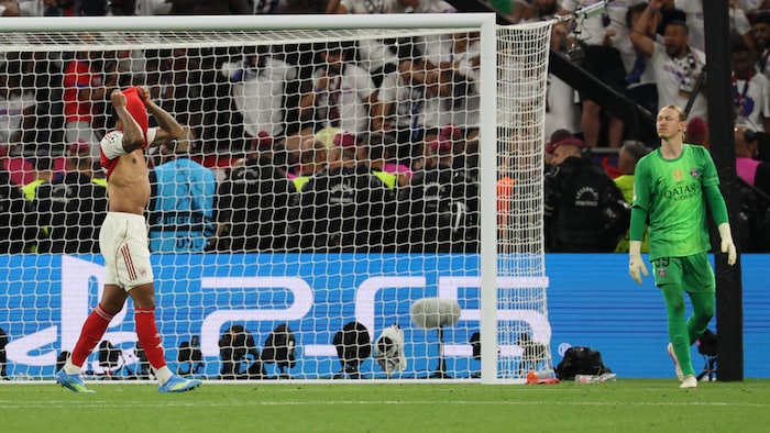 Deux joueurs de soccer sur un terrain devant un but.