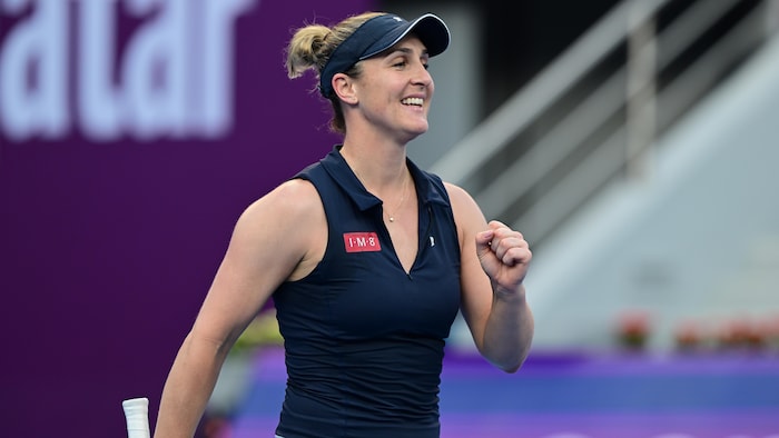 Une joueuse de tennis sourit et serre le poing.