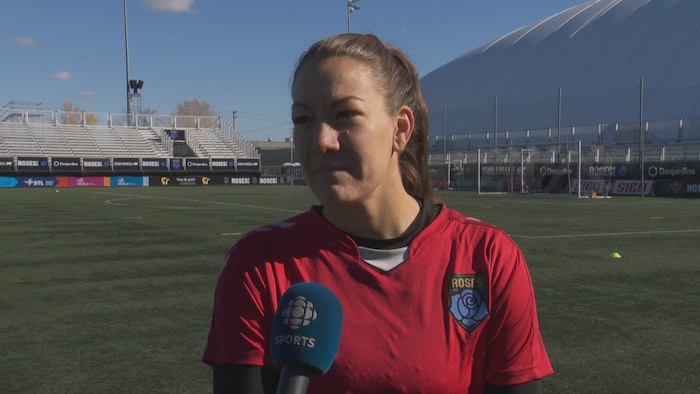 Une joueuse de soccer parle à un micro. 