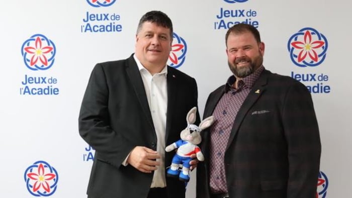 Gaël, à gauche, tient une mascotte des Jeux (un lapin habillé aux couleurs bleu-blanc-rouge). Jolain, à droite, sourit.