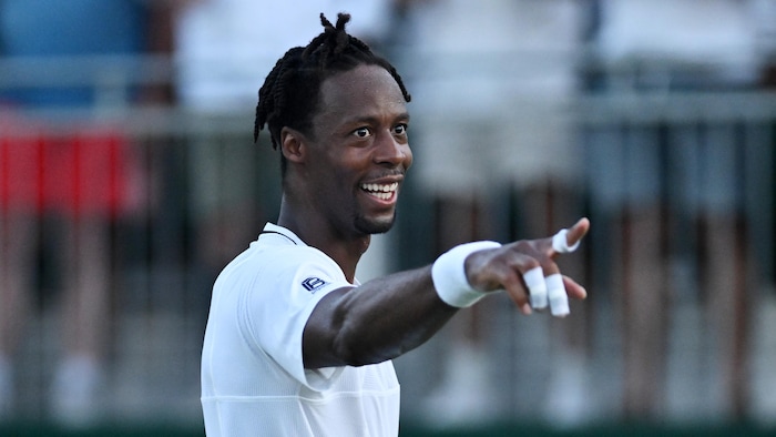 Un joueur de tennis pointe en direction du public.