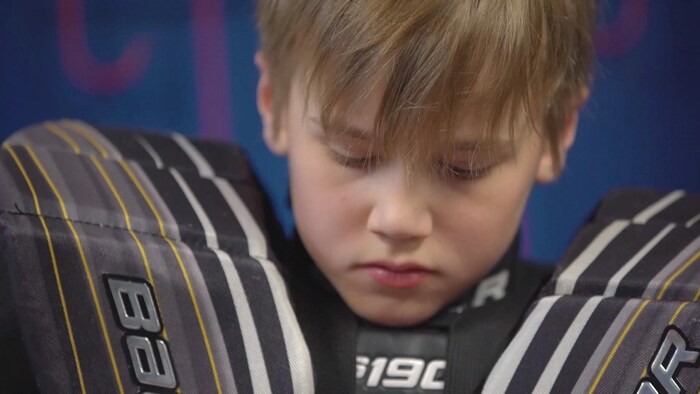 Un jeune gardien enfile son uniforme
