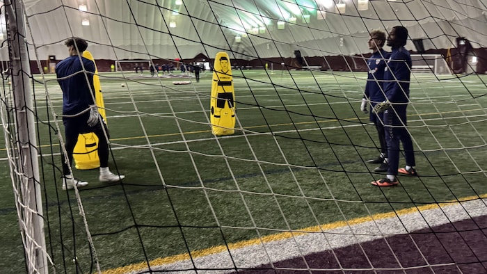 Trois gardiens de but de soccer sont en attente du ballon pendant un exercice.