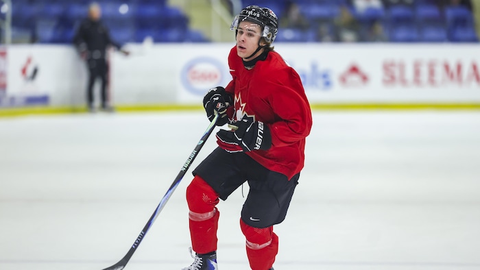 Un hockeyeur patine sur la glace.