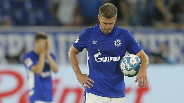 Un joueur tient un ballon dans un uniforme de soccer commandité par la compagnie Gazprom.